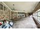 Large sunroom featuring brick walls, large windows, and stone flooring at 3330 Foxcroft Rd, Charlotte, NC 28211