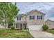 Charming two-story home boasts blue shutters, a well-manicured lawn, and attached two-car garage at 4026 Clover Nw Rd, Concord, NC 28027