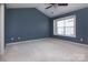 Spacious bedroom with vaulted ceiling, ceiling fan, neutral carpet, and natural light from a bright window at 4548 Antelope Ln, Charlotte, NC 28269