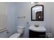 Efficient powder room features a stylish vanity, toilet, and tasteful mirror at 4548 Antelope Ln, Charlotte, NC 28269