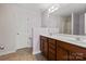 Bathroom featuring double sinks with wood cabinets and tile flooring at 4554 Craigmoss Ln, Charlotte, NC 28278