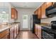 Well-lit kitchen features wood cabinets, granite countertops, stainless steel sink, and black appliances at 4554 Craigmoss Ln, Charlotte, NC 28278