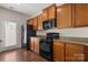 Functional kitchen with wooden cabinets, black appliances, and granite countertops, creating a practical cooking space at 4554 Craigmoss Ln, Charlotte, NC 28278
