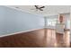 Spacious living room with hardwood floors, large window, ceiling fan, and open access to the kitchen at 4554 Craigmoss Ln, Charlotte, NC 28278