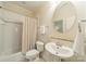 Bathroom with shower-tub, toilet, pedestal sink, and round mirror at 4599 Rustling Woods Dr, Denver, NC 28037