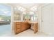 Vanity with wooden cabinets and multiple mirrors offers great lighting and counter space at 4599 Rustling Woods Dr, Denver, NC 28037