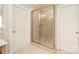 Neutral bathroom with a tiled walk-in shower featuring glass doors at 4599 Rustling Woods Dr, Denver, NC 28037