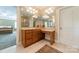 Bathroom with vanity, sink, and large mirror; the open doorway allows the adjacent main bedroom to be seen at 4599 Rustling Woods Dr, Denver, NC 28037