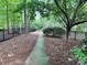 Scenic sidewalk lined by trees and a black metal fence, offering a peaceful walkway at 4599 Rustling Woods Dr, Denver, NC 28037