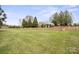 Large grassy backyard showcasing a level lawn area perfect for recreation or entertaining, accented by a brick retaining wall at 5119 Blackberry Ln, Matthews, NC 28104