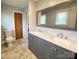 Bathroom featuring a double sink vanity, large mirror, and decorative floor tiles at 5119 Blackberry Ln, Matthews, NC 28104