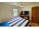 Bedroom with hardwood floors, ceiling fan, and natural light, with a TV on a bureau at 5119 Blackberry Ln, Matthews, NC 28104
