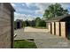 Long paved driveway leading to the house and a detached garage, complemented by wooden structures and gravel at 5119 Blackberry Ln, Matthews, NC 28104
