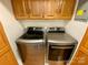 Laundry room with wood cabinets and stainless steel washer and dryer units at 5119 Blackberry Ln, Matthews, NC 28104