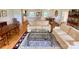 Bright living room featuring hardwood floors, sofas, a glass-topped coffee table, and an open layout to the kitchen and dining area at 5119 Blackberry Ln, Matthews, NC 28104