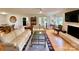 Cozy living room with hardwood floors, white fireplace, comfortable seating, and views into the dining area at 5119 Blackberry Ln, Matthews, NC 28104