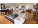Inviting living room with hardwood floors, neutral sofas, glass coffee table, and seamless flow to the kitchen and dining area at 5119 Blackberry Ln, Matthews, NC 28104