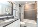 Well-lit bathroom with a grey tile shower/tub, granite vanity, and decorative artwork at 5125 Waxwind Ln, Charlotte, NC 28226