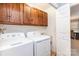 Functional laundry room with washer, dryer, upper cabinets, and sink near a door at 5125 Waxwind Ln, Charlotte, NC 28226