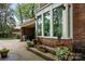 Brick home exterior with large windows, potted plants along the steps, and a covered patio area at 5510 Sardis Rd, Charlotte, NC 28270