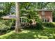 Backyard of a brick home with mature trees and landscaped patio and lawn at 5510 Sardis Rd, Charlotte, NC 28270