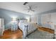 Serene bedroom featuring soft blue walls, a patterned bedspread, hardwood floors, and a ceiling fan at 5510 Sardis Rd, Charlotte, NC 28270