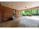 Spacious carport featuring brick walls and a serene view of the landscaped yard and green foliage at 5510 Sardis Rd, Charlotte, NC 28270