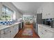 Bright kitchen featuring white cabinetry, stainless steel appliances, checkerboard backsplash, and brick flooring at 5510 Sardis Rd, Charlotte, NC 28270