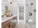 Well-lit bathroom with double vanity, wooden cabinets, and a glass-enclosed shower at 5604 Kingspan Dr, Charlotte, NC 28217