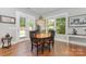 Cozy dining area featuring a round table, dark wood chairs, and natural light from the nearby windows and door at 5706 Sardis Hall Ct, Charlotte, NC 28270