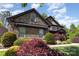 Stone two-story home featuring beautiful landscaping and a covered front porch at 5706 Sardis Hall Ct, Charlotte, NC 28270