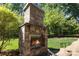 Outdoor fireplace made of stone with a chair at 5706 Sardis Hall Ct, Charlotte, NC 28270