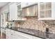 Stylish kitchen featuring a gas range, dark countertops, decorative backsplash, and light cabinetry at 5706 Sardis Hall Ct, Charlotte, NC 28270