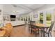 Open-concept living room with a fireplace, built-in shelving, and a dining area with beautiful hardwood floors at 5706 Sardis Hall Ct, Charlotte, NC 28270