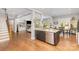 Spacious living space featuring a kitchen island, open living room, and staircase with wood floors at 5706 Sardis Hall Ct, Charlotte, NC 28270