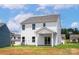 Exterior rear view of home with sliding glass door, small patio, and green backyard at 5716 Skinny Dr, Charlotte, NC 28215