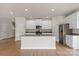 Bright, modern kitchen featuring a center island, granite countertops, stainless steel appliances, and white cabinetry at 5716 Skinny Dr, Charlotte, NC 28215