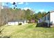 Large grassy backyard with mature trees and several outbuildings, offering ample space and privacy at 648 Dobson Farm Rd, Statesville, NC 28625