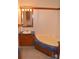 Cozy bathroom features wood vanity, corner tub, and tiled floors at 648 Dobson Farm Rd, Statesville, NC 28625