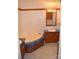 Cozy bathroom features wood vanity, corner tub, and tiled floors at 648 Dobson Farm Rd, Statesville, NC 28625