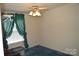 Bedroom with a fan, window with green curtains, and blue carpet at 648 Dobson Farm Rd, Statesville, NC 28625