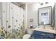 Bright bathroom featuring a vanity with blue cabinets and a shower with a floral curtain at 7215 Meyer Rd, Fort Mill, SC 29715