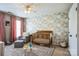 Bedroom featuring a crib, chair with ottoman, floral wallpaper, and natural light at 7215 Meyer Rd, Fort Mill, SC 29715