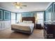 Spacious main bedroom featuring decorative trim, two windows, ceiling fan, and ensuite bathroom at 7215 Meyer Rd, Fort Mill, SC 29715