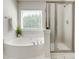 Bathroom features a soaking tub, walk-in shower, and a large window with natural light at 722 Sandy Green Ct, Fort Mill, SC 29715