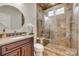 Bathroom features a walk-in shower with a bench, a granite vanity, and natural tile at 722 Sandy Green Ct, Fort Mill, SC 29715