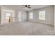 Large bonus room with neutral carpet, a ceiling fan, and natural light from two windows at 722 Sandy Green Ct, Fort Mill, SC 29715