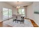 Dining room with a gray table with seating for six plus a sliding glass door to the screened porch at 722 Sandy Green Ct, Fort Mill, SC 29715