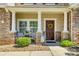 Inviting front porch with stone pillars, seating, and a decorative wreath on the front door at 722 Sandy Green Ct, Fort Mill, SC 29715