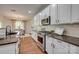 Kitchen features granite countertops, a stainless steel range and microwave, and bright white cabinets at 722 Sandy Green Ct, Fort Mill, SC 29715